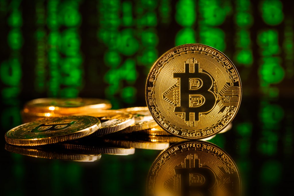 bitcoins cryptocurrency in front of green matrix background.