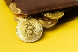 What is a Bitcoin wallet? Bitcoin coins in wallet on yellow background